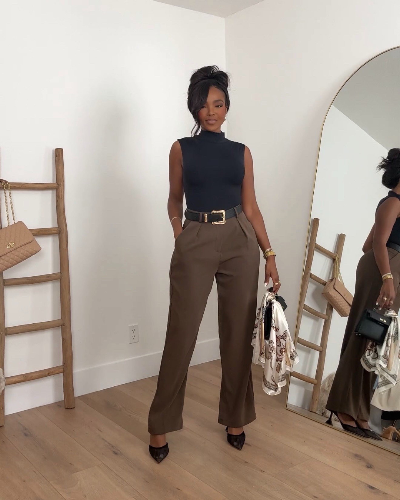 Scroll to shop this polished neutral outfit featuring a black sleeveless mock-neck top styled with tailored chocolate brown trousers and a statement belt for a refined, timeless look. Chocolate tones are trending right now and work perfectly for spring outfits 2026 and business casual workwear, while classic pieces like these can be styled multiple ways so the cost per wear keeps dropping over time.

Perfect for work outfits, business casual meetings, dinner dates, or elevated everyday outfits.

5'4" | 138 lbs | 34D bust | 27" waist | 40" hips

#LTKvlog #LTKootd