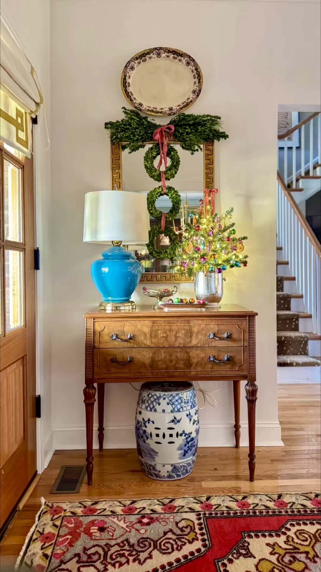 Christmas entryway vignette 
Tabletop Christmas Tree 
Shiny Brite Ornaments 
Burlwood server 
Greek key mirror 
Boxwood wreath 

#LTKSeasonal #LTKHome #LTKHoliday