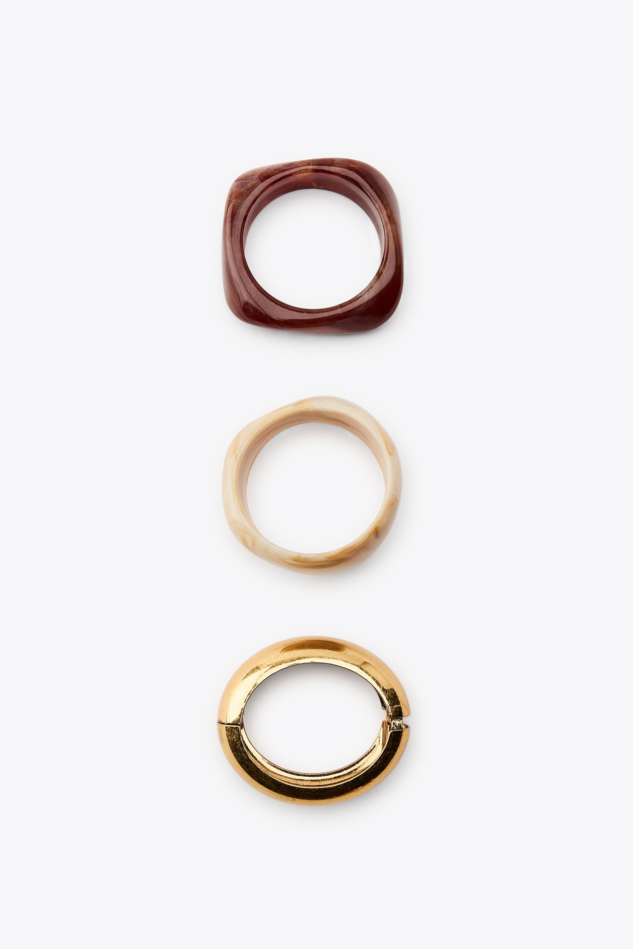 Pack of three rigid bracelets of different sizes, materials, and embossed shapes. | Zara US