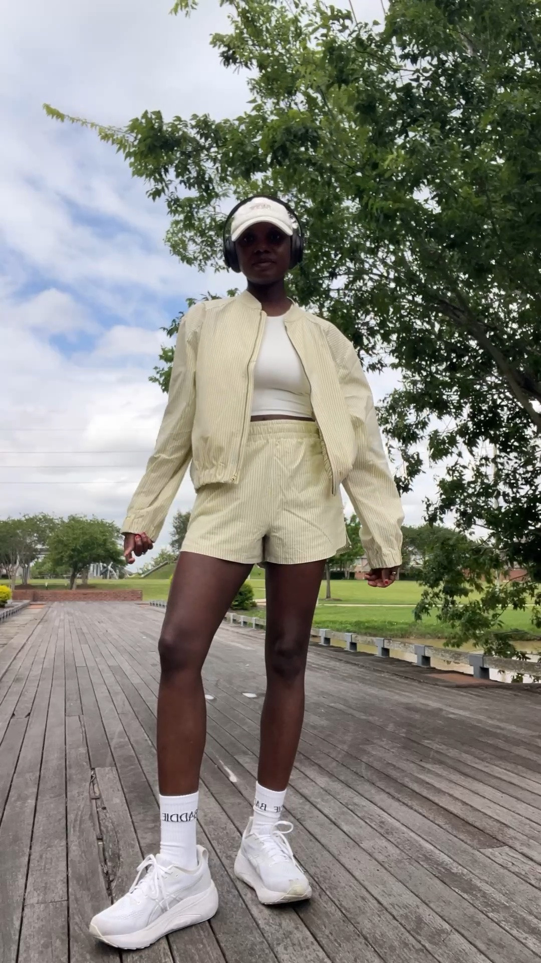 Seersucker striped jacket and shorts, white dad hat and white walking sneakers.