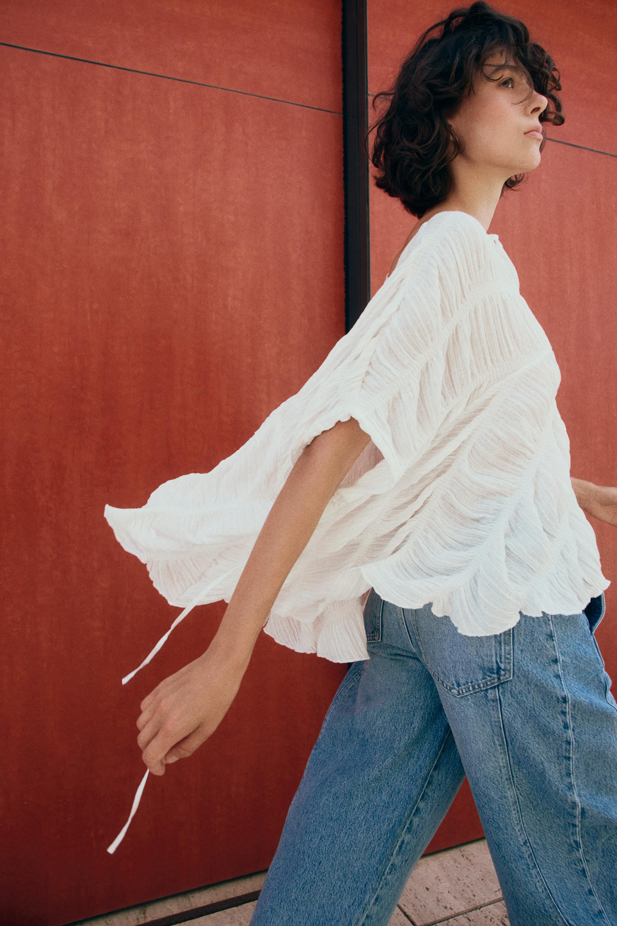 Round neck top with cape-style sleeves. Textured fabric with gathered detailing. Asymmetric hem. ... | Zara US