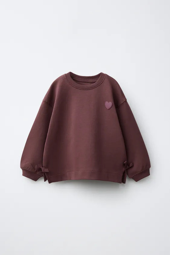 Round neck sweatshirt with long sleeves featuring ribbed cuffs and hem. Side bow appliqu\u00e9 an... | Zara US