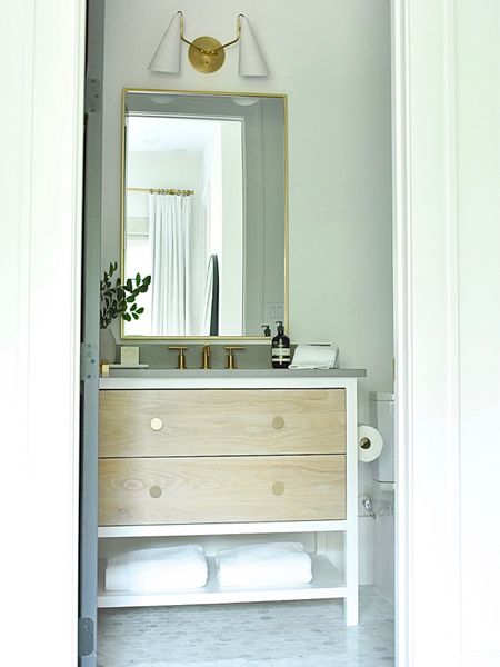 Bathroom decor. Bathroom cabinet hardware.  Vanity mirror and sconces.  Brass faucet.  Brass toilet paper holder. Best hand soap. Organic bath towels.  Bathroom sink  

#LTKstyletip #LTKhome #LTKunder50