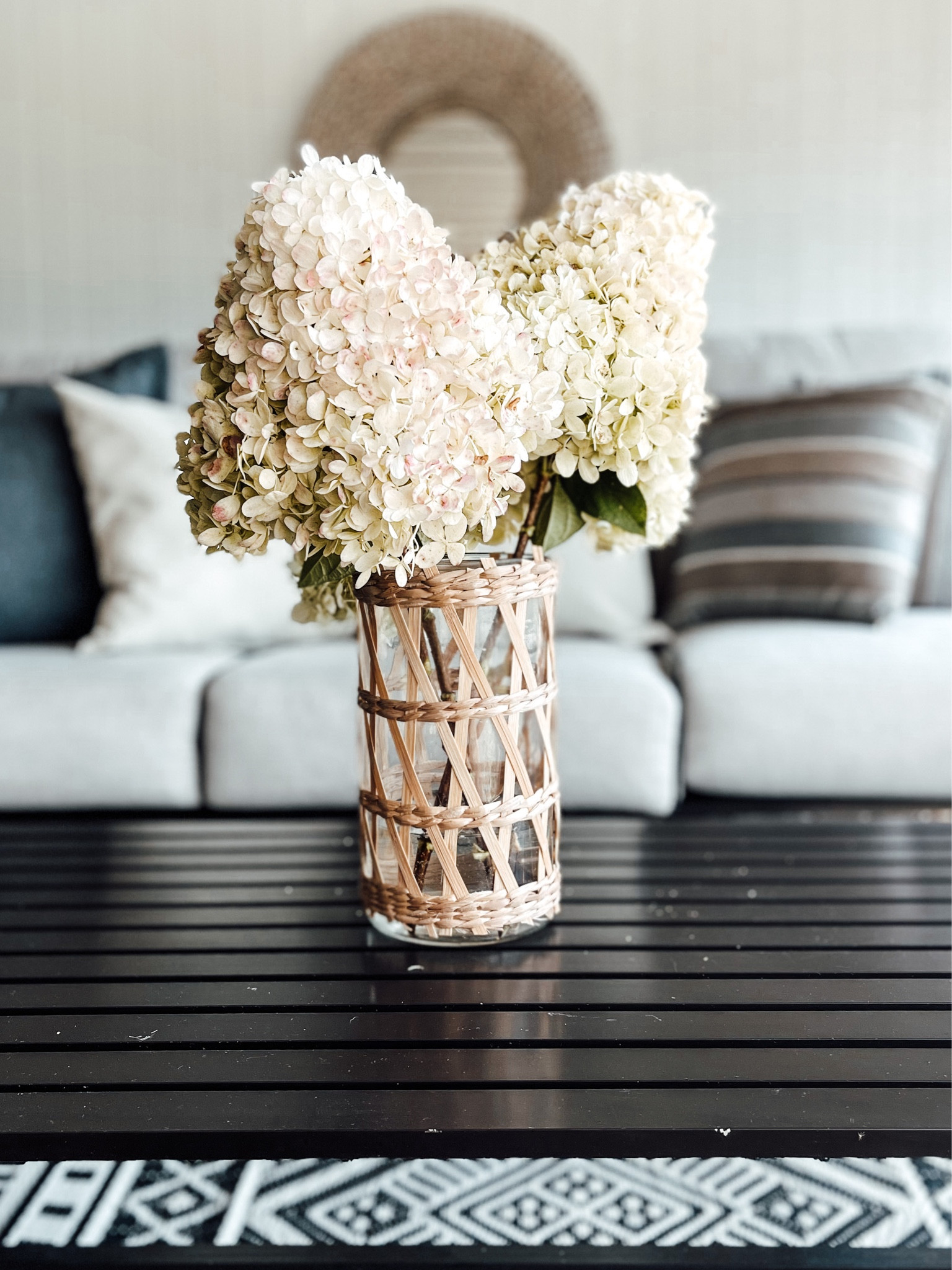 Outdoor covered patio
- outdoor coffee table
- bamboo/ straw weave vase Or
- pillar candle holder
- circle sea grass mirror 

#LTKSeasonal #LTKhome #LTKU