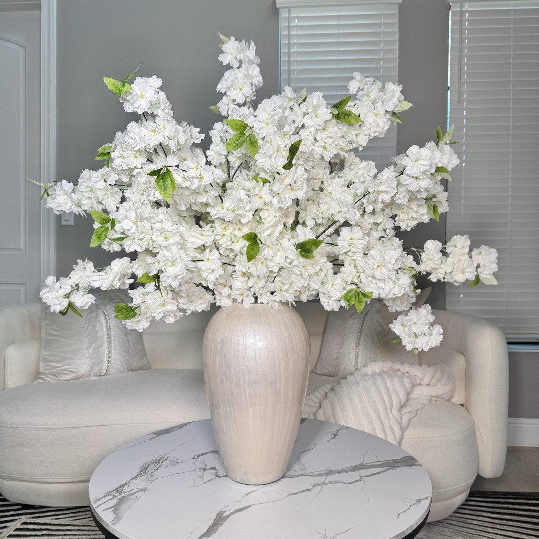 Obsessed with how this oversized white cherry blossom arrangement instantly elevates the entire living room 🤍🌸 The perfect neutral decor piece for a coffee table, entryway, or console. It adds that luxe, high-end look without needing fresh flowers and works beautifully for spring styling or year-round home decor. If you love timeless, elegant interiors, this is such an easy upgrade. 

 #LTKmomlife #LTKActive #LTKHome