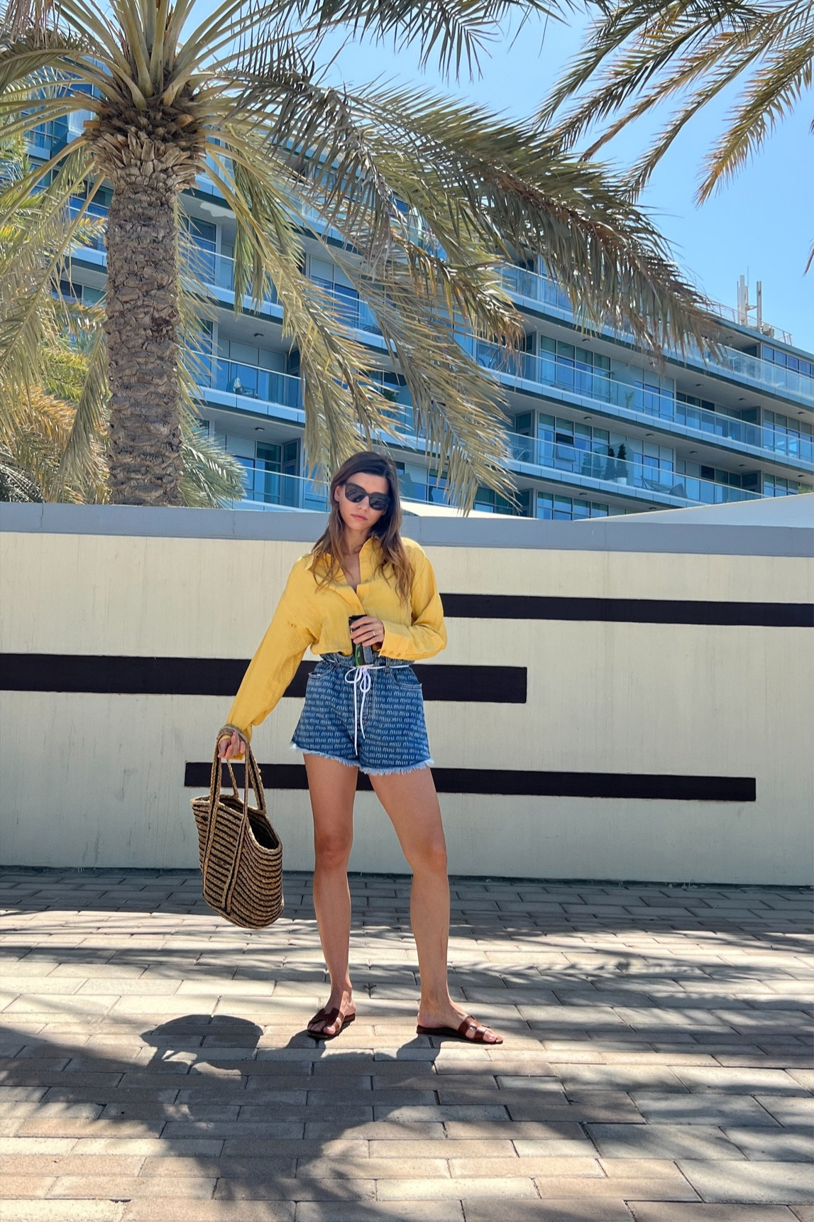 This casual outfit features a pair of Miu Miu denim logo-print shorts that add a playful and trendy touch to the ensemble. Paired with the shorts is an orange shirt, which creates a bold and vibrant color contrast. To complete the look, a pair of Hermes Oran sandals adds a touch of luxury and sophistication. Overall, this outfit is perfect for a casual day out with friends or running errands in style.

#LTKstyletip #LTKSeasonal #LTKFestival