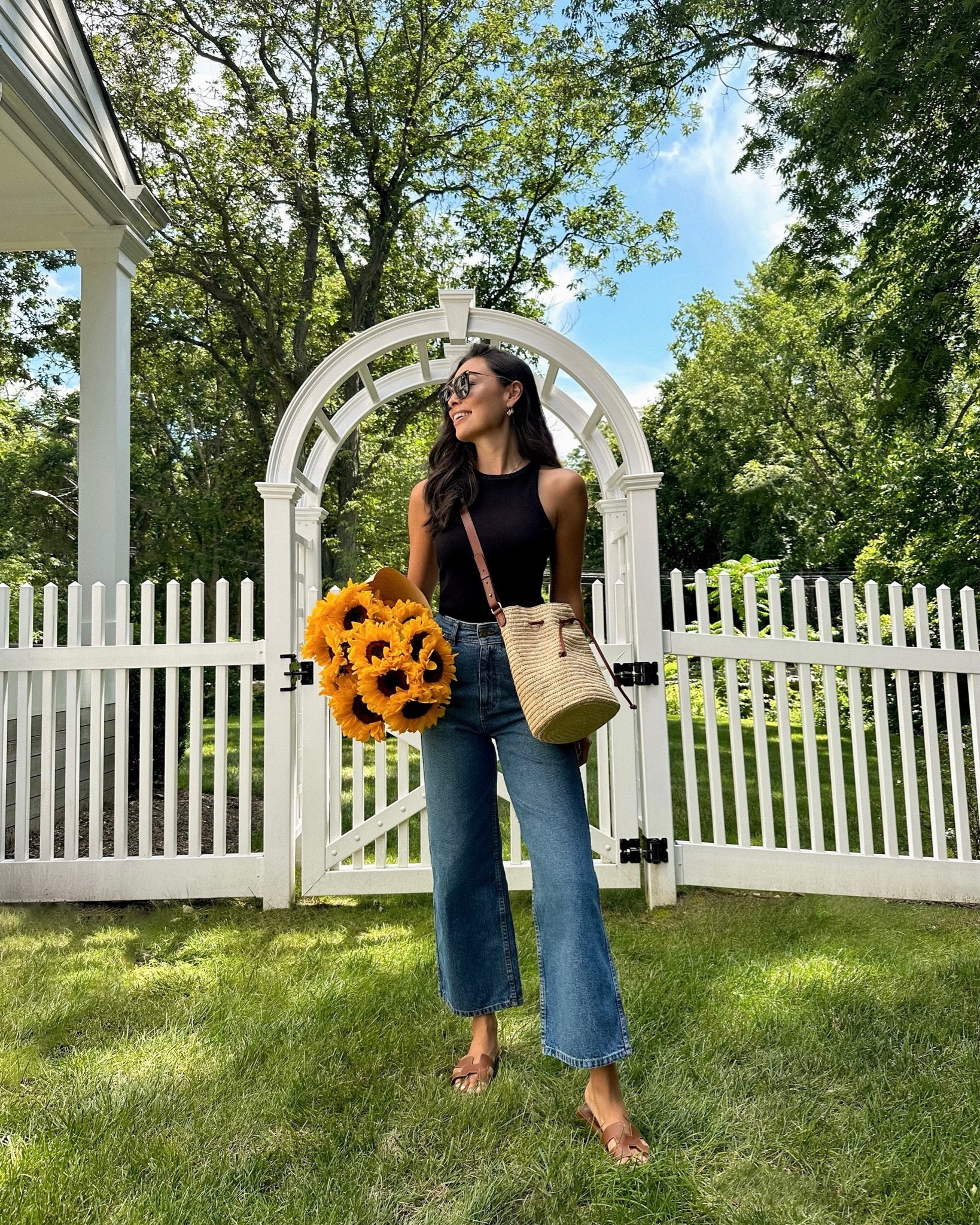 Kat Jamieson wears a black tank with denim jeans. Hermes Oran sandals, bucket bag, spring outfits, summer outfit, jean, arbor, garden. Jeans are sold out from Sezane, similar below. 

#LTKhome #LTKitbag #LTKSeasonal