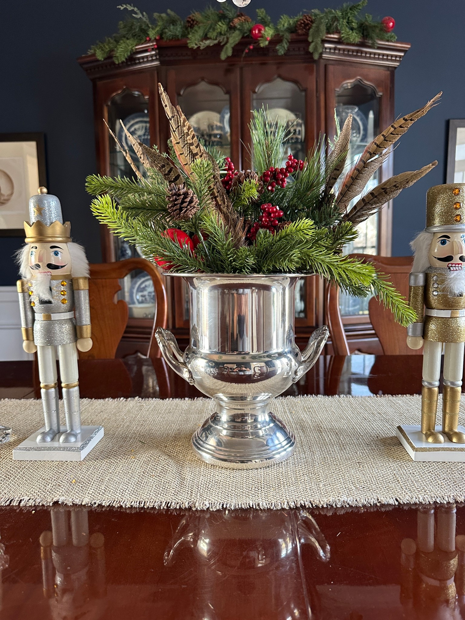 Silver urn / champagne bucket with Christmas greenery and feathers for a Ralph Lauren Christmas centerpiece - with nutcrackers on the sides. 

#LTKHoliday #LTKSeasonal #LTKHome