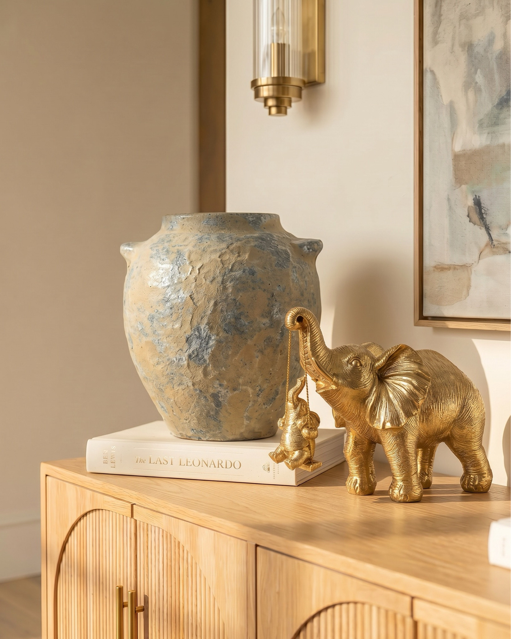 Shop the look:
* Oak wood extendable dining table
* Wood cane dining chair
* Beige jute rug
* Wood oak console credenza 
* White ceramic vase 
* Distressed terracotta vase
* Ceramic table lamp 
* Brass gold decor figures 
* Decor book 
* Oak wood display cabinet 
* Brass gold chandelier 
* Glass brass wall sconce 
* Blue subtract wall art

#LTKhome #LTKsale #LTKstyletip