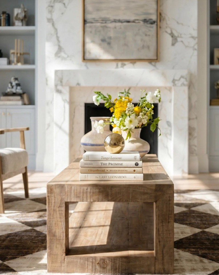 • White upholstered sofa (modern clean lines)
• Light wood frame accent chair (neutral cushion)
• Chunky knit throw blanket (cream / beige)
• Light wood rectangular coffee table (minimal / modern)
• Neutral checkered area rug (brown / cream pattern)
• Marble fireplace surround (white with gray veining)
• Large abstract landscape wall art (neutral tones, gold frame)
• Built-in shelving (painted soft gray)
• Decorative books (neutral stacked styling)
• Small ceramic decor objects (matte black / stone finish)
• Brass candle holders (modern minimal)
• Glass decorative vases (clear / smoked)
• Wood ceiling beams (light natural finish)
• Round flush mount ceiling light (white globe)
• Ceramic vase (rounded neutral tone) • Fresh floral arrangement (yellow + white flowers) • Decorative tray (light wood or stone) • Stacked coffee table books (neutral covers) • Small brass sphere decor object
• Light wood side table (open shelf design) • Blue and white ceramic ginger jar • White table lamp (fabric shade, brass detail)
• Light wood sideboard cabinet (cane / woven door fronts) • Cane panel credenza (natural oak finish) • Blue and white ceramic ginger jars (traditional style) • White ceramic bowl (centerpiece decor) • Brass decorative tray (organic shape) • Floral still life wall art (gold frame) • Neutral floral wallpaper (textured / vintage style) • Brass wall sconces with white glass shades • White table lamp with brass hardware • Large ceramic table lamp base (blue/white pattern)

#LTKsale #LTKhome #LTKstyletip