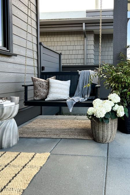 Everyone, and I mean everyone, needs a glorious porch swing if they have the space. This two-seater porch swing is perfect for crisp cozy mornings or warm evenings outside with the family. I also found this awesome wicker outdoor planter and this black self-watering planter. Grouped with this sturdy concrete outdoor side table makes this zone the most perfect oasis you’ve ever seen. 

You can read more details at [blog post link here] and shop all the outdoor furniture from my favourite place to snag home decor in Canada! 

#Ad, #WayfairCanada, #WayfairCAHome, @wayfaircanada 

#LTKsalealert #LTKstyletip #LTKhome