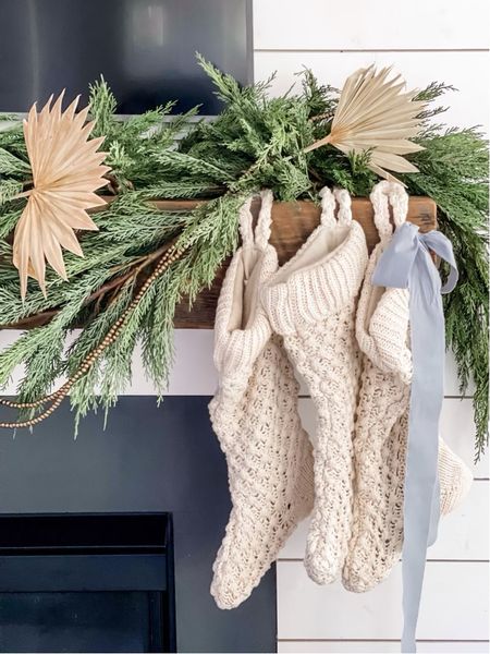 Neutral Christmas with a coastal chic vibe for your cozy living room! Cedar garland with blue ribbon and knit stockings 

#LTKhome #LTKHoliday #LTKSeasonal
