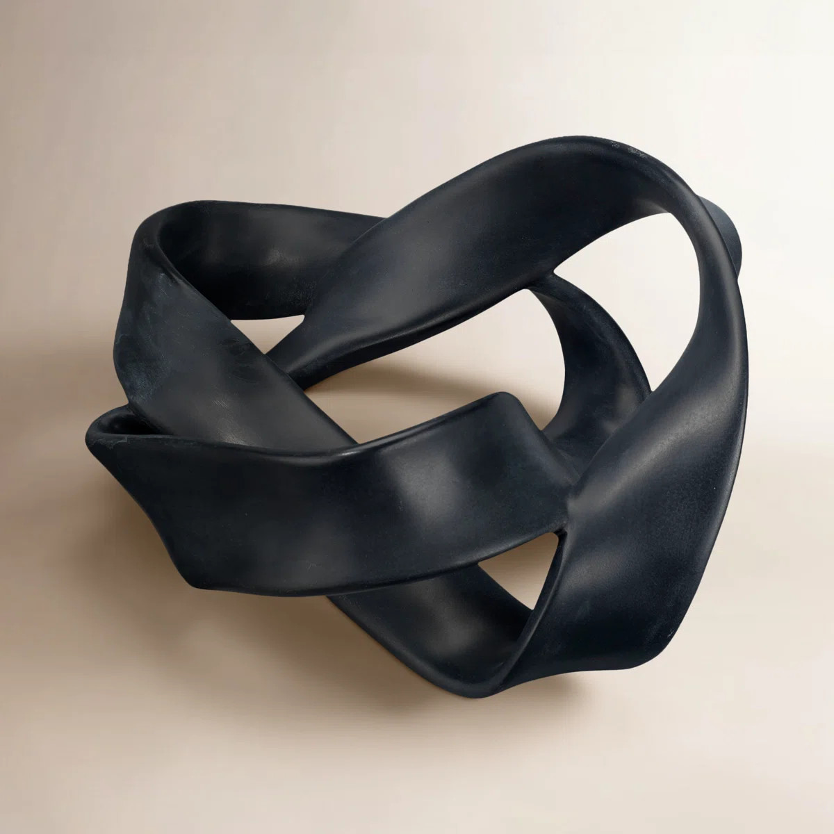 Substantial straps of black resin wrap and twist around a central void in the sculpture, creating... | Wayfair North America