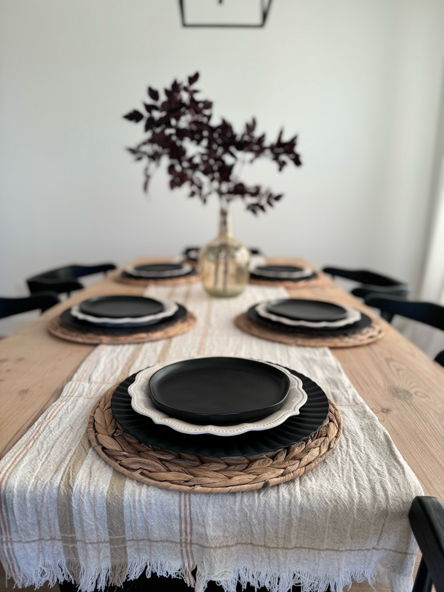Create an elegant fall-inspired dining tablescape by incorporating deep, rich tones and natural textures. This table features layered neutral linens with woven placemats, adding a rustic yet refined foundation. The black plates offer bold contrast, while the centerpiece—a simple glass vase filled with dark seasonal branches—brings an organic touch. This minimalist yet sophisticated look perfectly balances modern and earthy elements, making it ideal for any autumn gathering.

#falltablescape #falldecor #thanksgivingdecor #halloweendecor #fallhomedecor 

#LTKSeasonal #LTKFamily #LTKHome