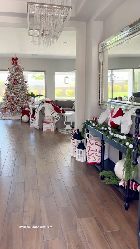 Flocked Christmas tree and entryway garland and giant peppermints at Modern Farmhouse Glam. My pine garland sells out fast every year! 

Christmas decorations. Holiday decor. Home decor. Candy canes. Red and white peppermint candy decor. Oversized large mirror. Crystal chandelier. Rug  

#LTKSeasonal #LTKHoliday #LTKhome