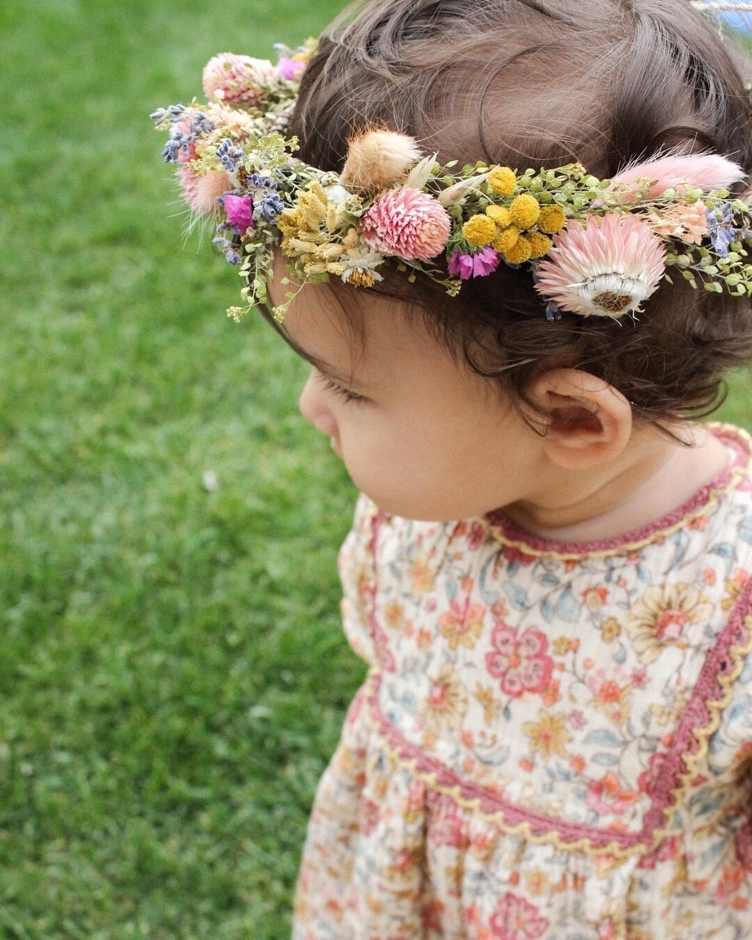 This colorful meadow flower crown is a dreamy accessory for newborn photos, cake smashes, flower girls, bridal showers, and weddings. Handcrafted with English lavender, blush strawflowers, amaranth, yellow yarrow, orange tansy, bunny tails, and natural greenery, it captures the beauty of a wildflower field in full bloom. Available in sizes from newborn to adult, this lightweight crown is a timeless keepsake for life’s sweetest moments. #DriedFlowerCrown #FlowerGirlCrown #BohoWedding #WildflowerWedding #BabyPhotoProp #BridalCrown #PreservedFlowers #RusticWedding #LTKWedding #FloralAccessories