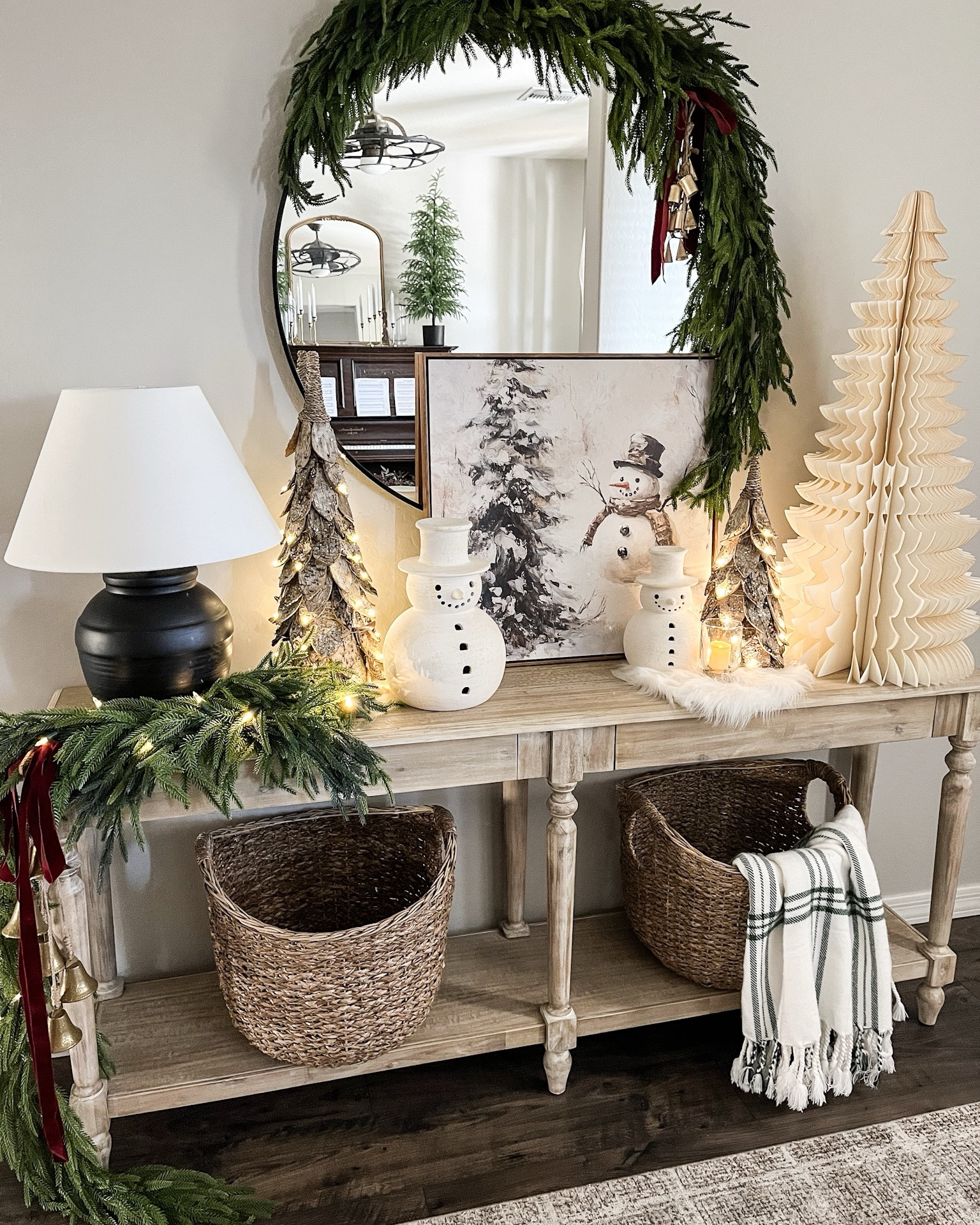 CHRISTMAS console styling!  Follow @lifeinmyarizonahome on Instagram for more holiday ideas and inspiration. 

I went for a fun whimsical look with this oversized paper tree and these adorable snowmen. I absolutely love these birch trees, that can be set on a timer, and this beautiful artwork helps complete the look!  

For reference:
Mirror garland used one 5ft Norfolk garland and 3 additional Norfolk stems. 
Artwork is in the 24x24 inch size.
The birch trees are the medium and small size. 
The table garland is a 6ft Norfolk garland with 3 additional Norfolk stems. 
The bells on the mirror are a simple DIY with 6 mini bells tied with jute string. 

#christmasdecor #homedecor #christmasstyling #consoletable #christmasentryway 

#LTKHome #LTKHoliday #LTKSeasonal