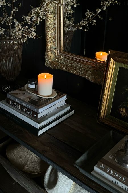 Cozy layering on my entry console with my favorite design books, Jenni kayne home candle, and vintage mirror. Love my Terrain hurricane vase!