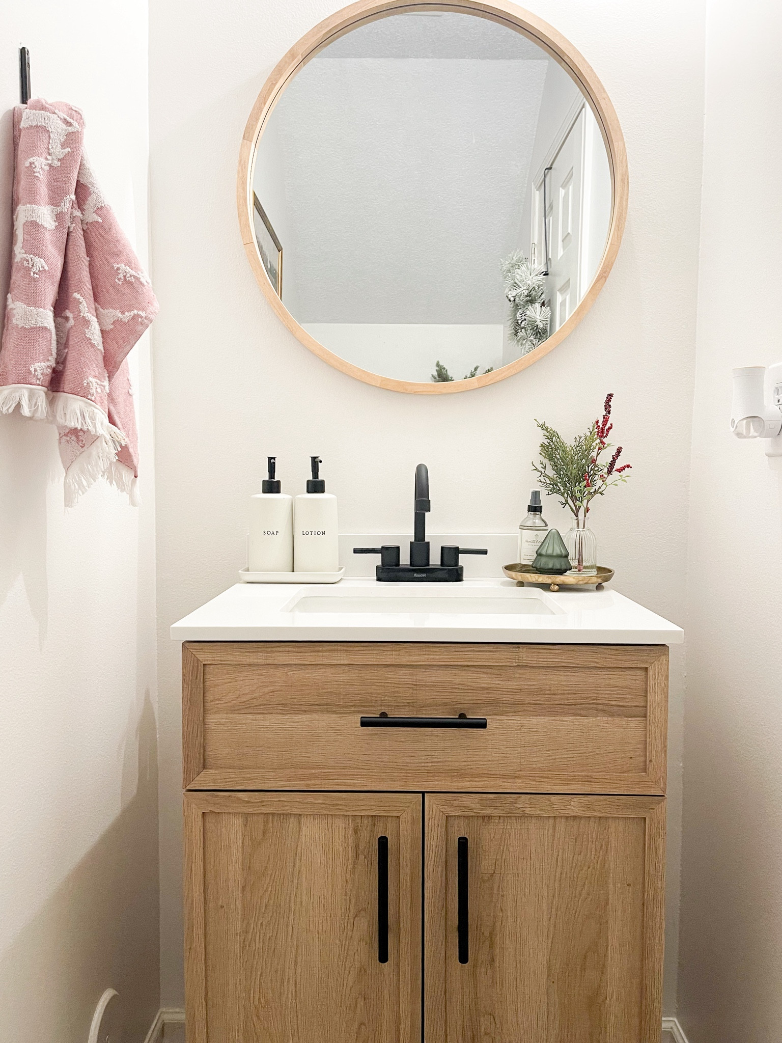 Christmas bathroom decor. Sale alert. Christmas greenery. Round mirror. Oak wood sink vanity. 

#LTKCyberWeek #LTKHoliday #LTKhome