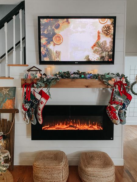 Needlepoint stockings from Lands end, stocking holders, faux greenery from Amazon, jute ottomans from Overstock, paintable nativity from Amazon 
Wall mounted electric fireplace, floating wood mantel Lowes 
Velvet ribbon, multicolored battery operated lights

#LTKhome #LTKunder100 #LTKSeasonal