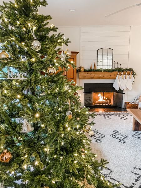 Christmas home decor.  Christmas tree from Home Depot.  Christmas tree gold bulb ornament.  Rugs USA Moroccan area rug.  Neutral 8 X 10 area rug.  Black arched mirror.  White faux fur stockings.  Spruce Christmas garland.  Modern wooden trees.  Black candlestick holders from Amazon.  Gold antique bells.  



#LTKhome #LTKSeasonal #LTKHoliday