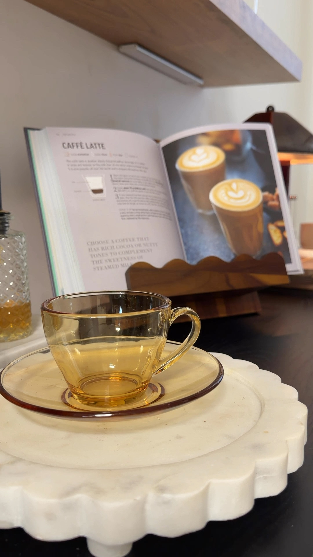 The art of the morning ritual. ☕️✨
My latest addition, the scalloped book stand from @moncurhome #gifted 
It’s more than a place to rest my favorite coffee book, it’s a dedicated space for inspiration while I brew. Crafted from rich, warm wood that catches the morning light perfectly. Truly the centerpiece my coffee bar was waiting for.


#coffeeaesthetic #homedesign #coffeebar #editorialhome

#LTKdayinmylife #LTKMothersDay #LTKHome