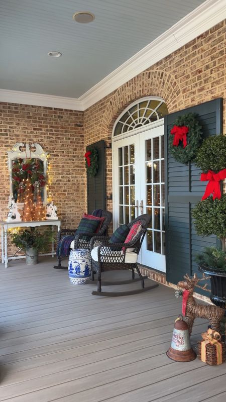 Classic Christmas front porch featuring garland, lights, red ribbon and  Christmas decor with a touch of blue and white with the chinoiserie garden stools! 

#LTKhome #LTKSeasonal #LTKHoliday