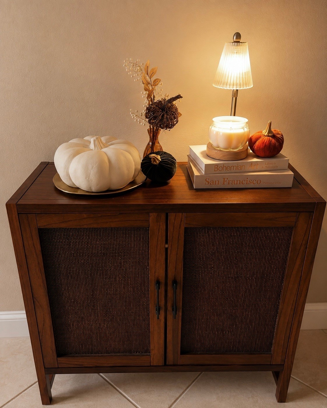 Fall decorating without making the house look like a pumpkin patch exploded in it 😂🍂🤎 I love mixing a few seasonal pieces into my everyday neutral decor. The warm wood, soft lighting, velvet pumpkins, creamy white pumpkin and little touches of gold make this corner feel so cozy for fall while still working with the rest of my home.

fall decor, fall home decor, neutral fall decor, Amazon fall decor, Amazon fall finds, Amazon home decor, Amazon home finds, fall decorating ideas, neutral fall decorating, elegant fall decor, cozy fall decor, classy fall decor, subtle fall decor, elevated fall decor, fall entryway decor, entryway fall decor, console table decor, accent cabinet decor, cabinet styling, fall console table, pumpkin decor, neutral pumpkin decor, white pumpkin decor, velvet pumpkins, fall floral stems, fall vase filler, autumn stems, gold decor tray, decorative gold tray, cordless table lamp, rechargeable table lamp, small table lamp, ambient lighting, cozy lighting, decorative books, coffee table books, candle warmer lamp, fall candle decor, warm neutral decor, brown home decor, neutral home decor, organic modern decor, transitional home decor, traditional home decor, cozy home aesthetic, autumn home decor, fall home inspiration, fall 2026 decor, affordable fall decor, designer inspired decor

#LTKSeasonal #LTKHome #LTKSaleAlert