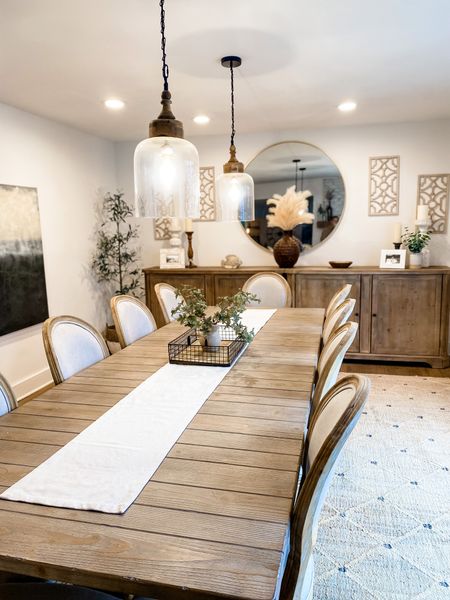 Neutral dining room. Extra long diy credenza, by simply pushing two side by side. Natural jute rug. Tans and blacks. Abstract artwork. Glass pendants with wood accents. Oversized round mirror. French country round back dining chairs. 
#competition

#LTKFind #LTKhome #LTKstyletip