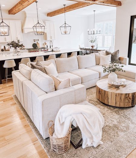 Living room, sectional, round coffee table, wood coffee table, neutral rug, gray rug, white vase, silver dollar eucalyptus stems, counter stools, kitchen pendants, black chandelier, modern chandelier, basket 

#LTKunder50 #LTKfamily #LTKhome