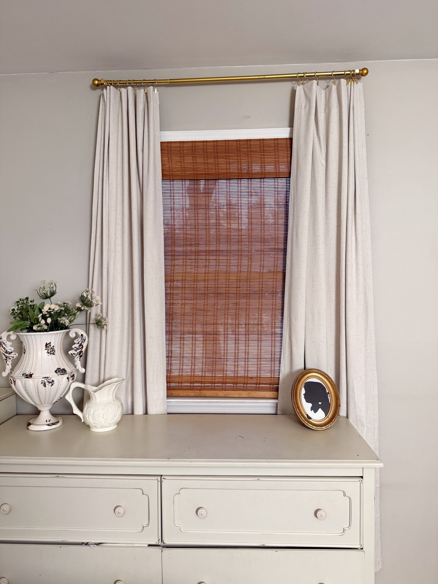 Soft layers = instant cozy. These linen curtains paired with natural bamboo shades completely changed the feel of this space—warmer, softer, and more elevated without doing too much. Styled with a few vintage touches to keep it feeling collected and lived-in.

#ltkhome #cozyhome #windowdecor #neutralhome #cottagestyle #layereddecor #vintageinspired #homedetails
