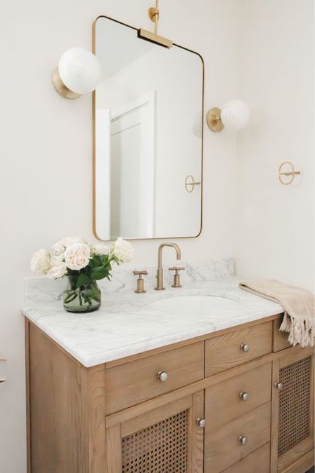 Guest bathroom 

Bright and airy guest bath with wall sconces, wall mirror, Kohler faucet, pottery barn vanity, rattan towel hook. 

#LTKHome