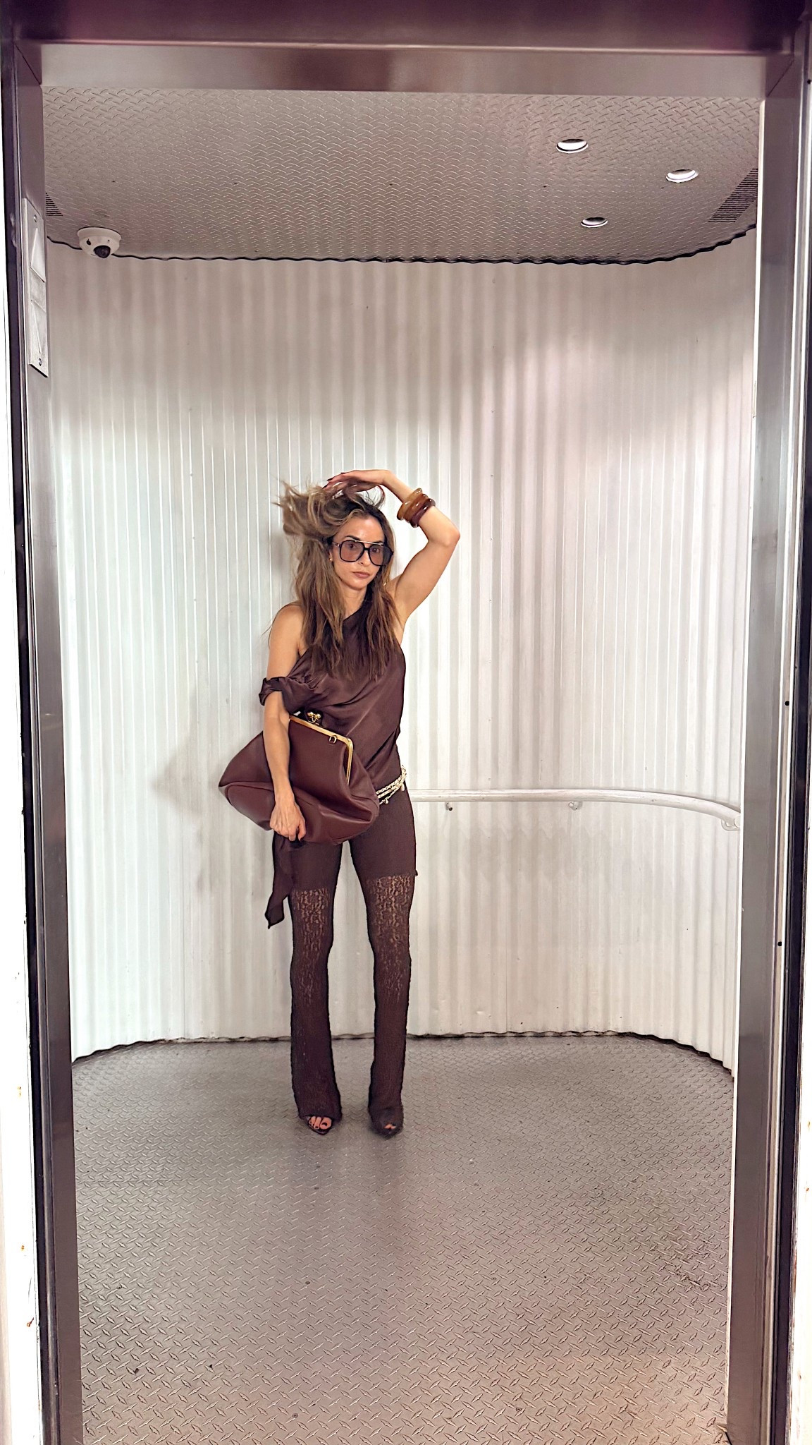 Head-to-toe brown never looked this luxe 🤎. I styled a silky asymmetric top with sheer lace flared pants for that perfect mix of sultry and elevated. A chain belt cinches the look with subtle shine, while oversized sunglasses and stacked bangles keep it cool and modern. The oversized brown clutch completes the rich monochrome vibe — effortless, chic, and ready for fall.

#LTKStyleTip #LTKParties #LTKSeasonal