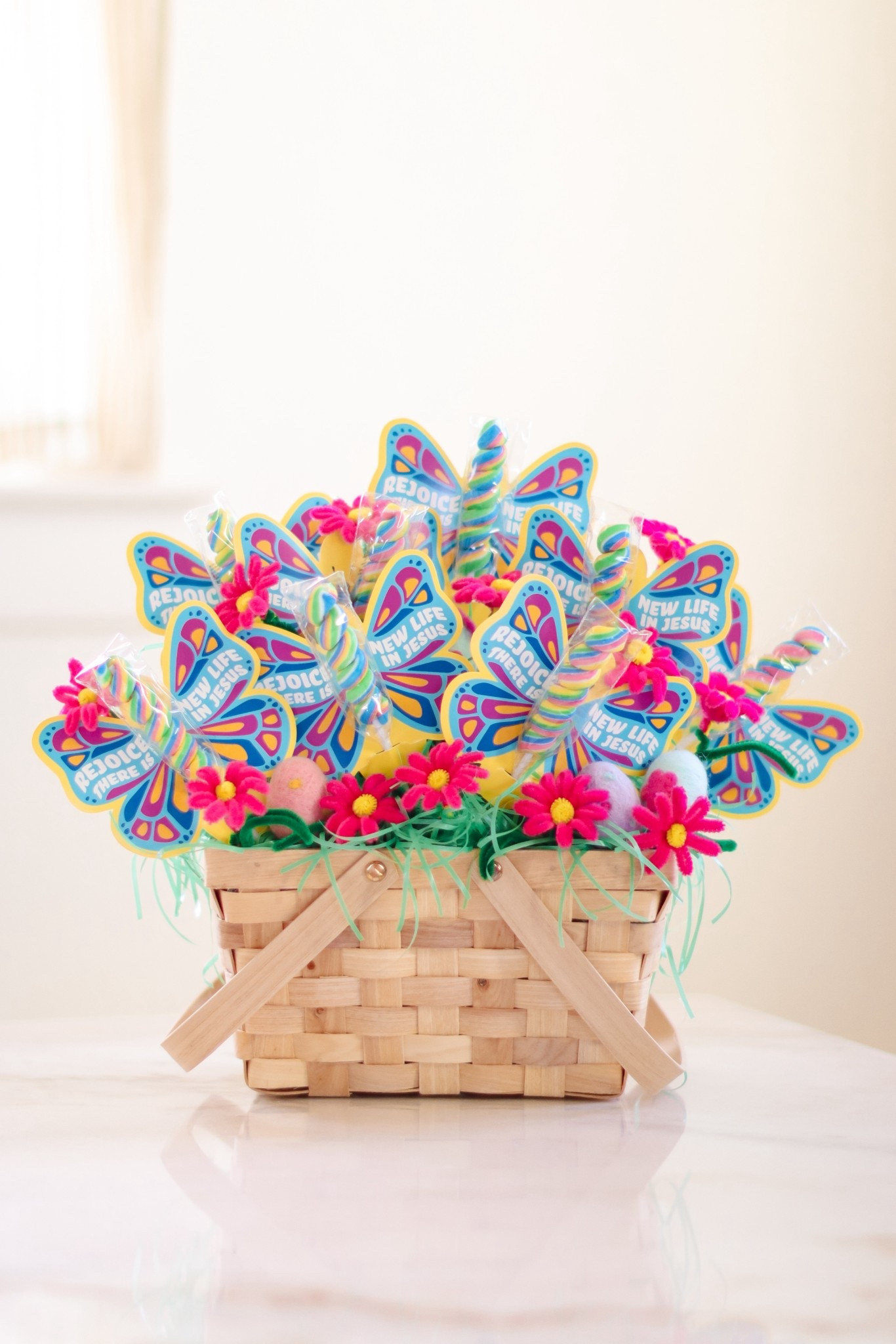 These butterfly Easter handouts turned into the sweetest little gift baskets! 🦋🧺✨

I tucked these cute butterfly lollipops into a picnic basket with foam balls for layering and Easter grass for texture. Then I filled in the empty spots with DIY flowers made from chenille stems, and added felt Easter eggs for extra fun. 

#LTKmomlife #LTKKids #LTKSeasonal