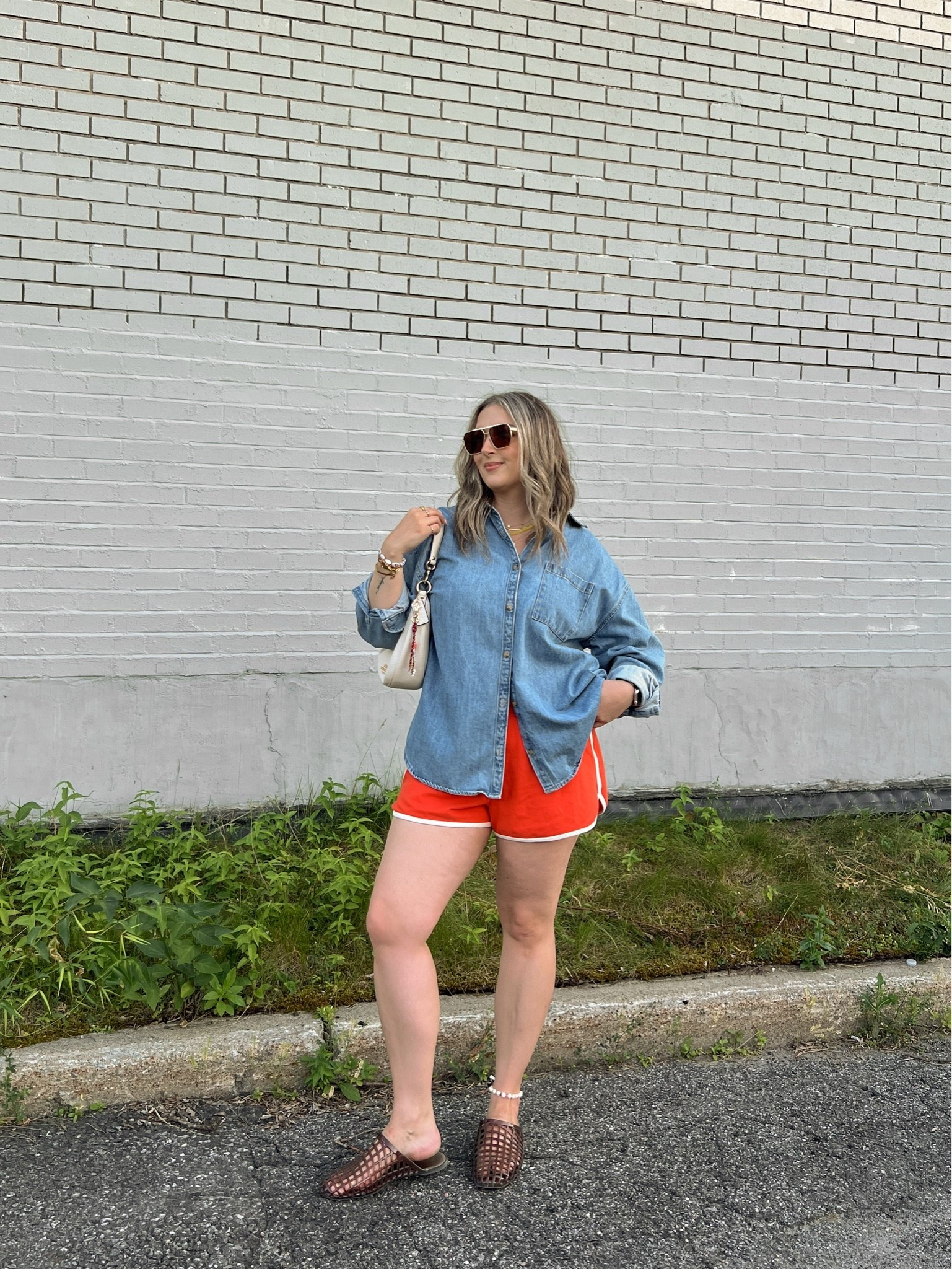 Casual summer outfit! Wearing my usual size L in the red orange dolphin shorts and my fave denim shirt. Jelly shoes are comfy and not sweaty, I’m a 9.5-10 and wear a 10. Canadian shirt and shoes link under “similar products”