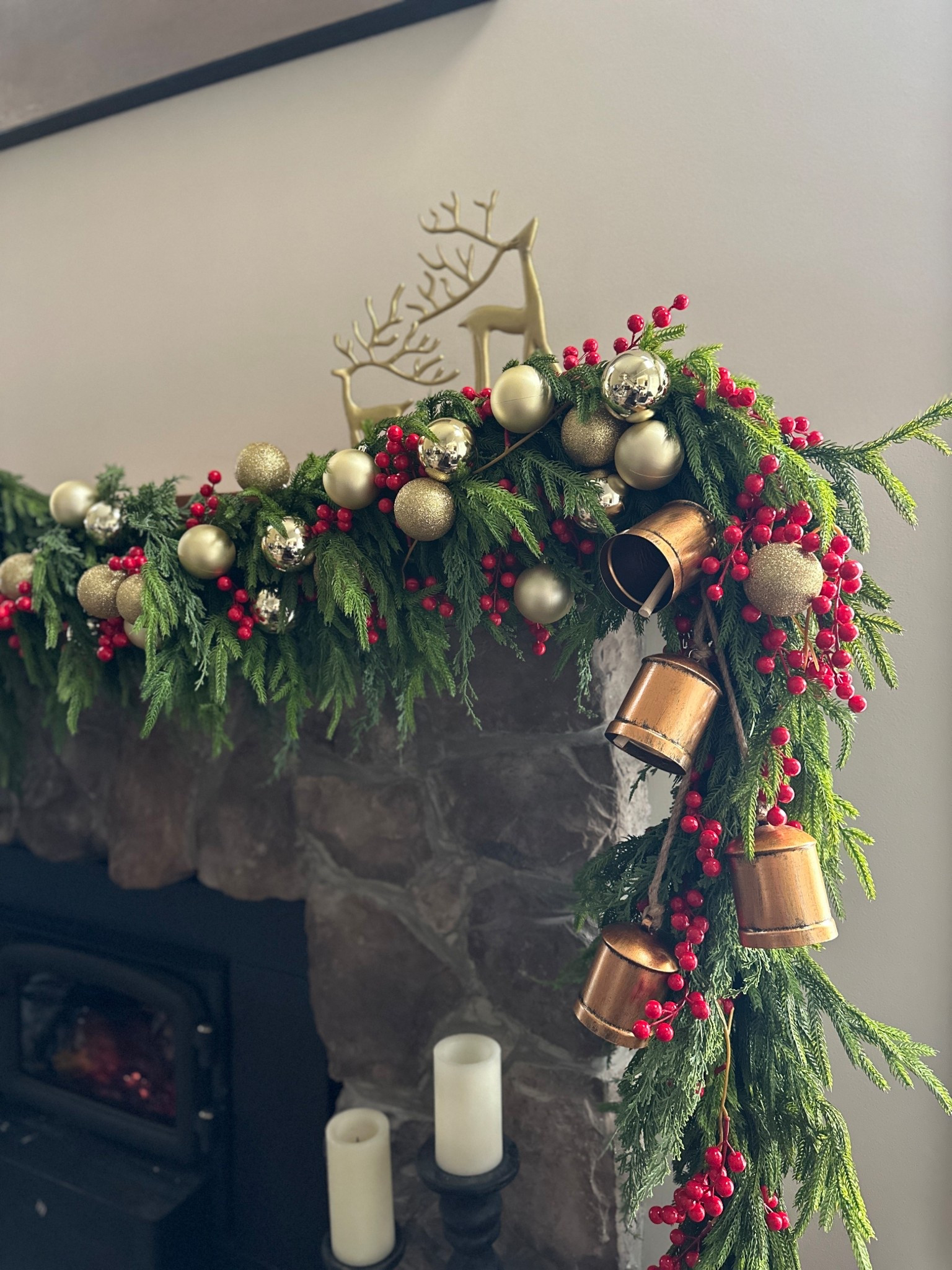 Simple and traditional fireplace mantel holiday garland styling -
Layers of Norfolk pine garland with red berries, gold ornaments, and rustic bells  

#LTKHoliday #LTKHome #LTKFindsUnder100