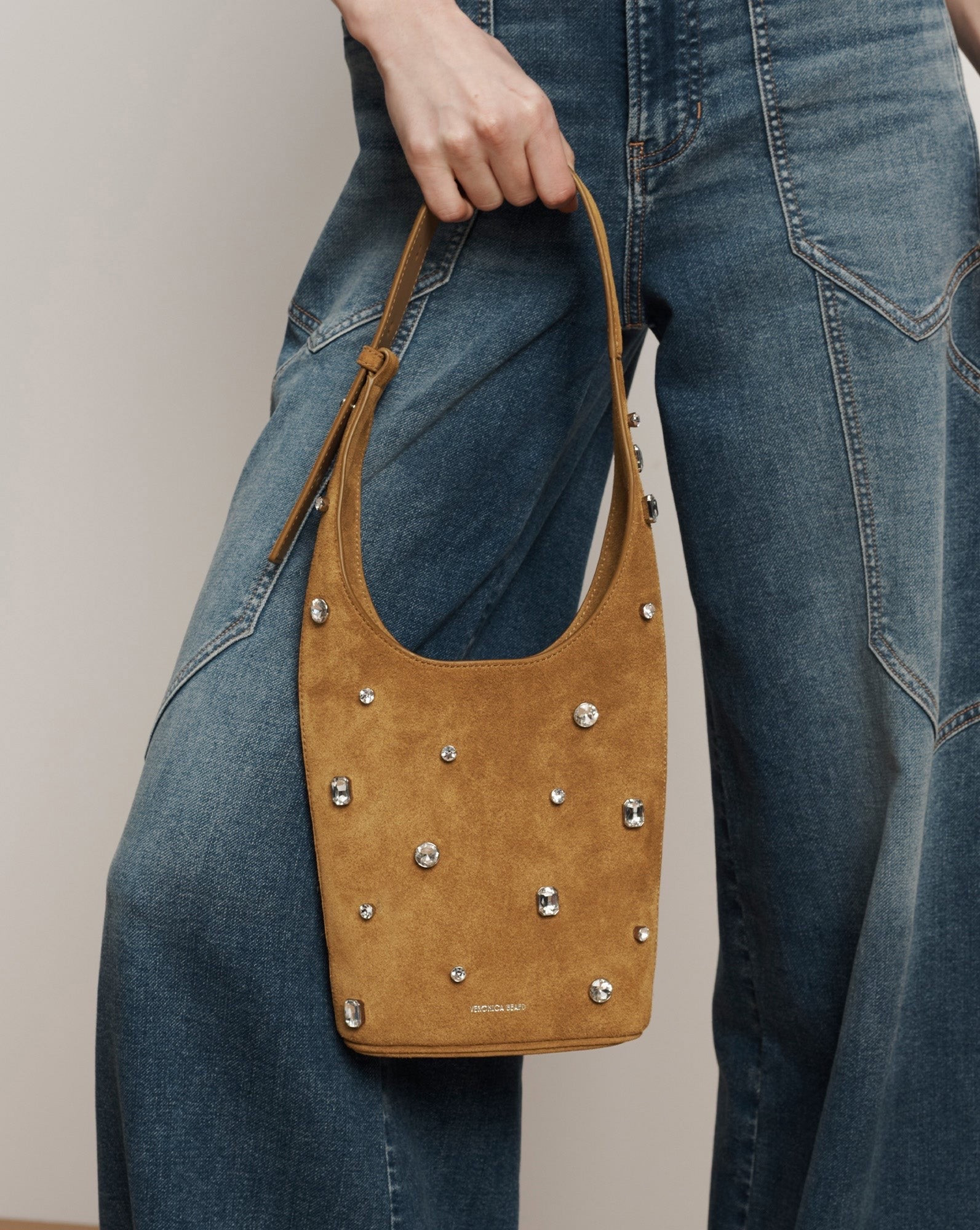 Embellished Loop Bag
Tan Suede Crystal Shoulder Bag

A petite bag that makes a big statement. Crafted from tan Italian suede and embellished with assorted crystals, the Loop shoulder bag is defined by its compact, elongated silhouette. An adjustable collar-stud buckle strap allows for comfortable over-the-shoulder wear

#LTKootd #LTKTravel #LTKWorkwear