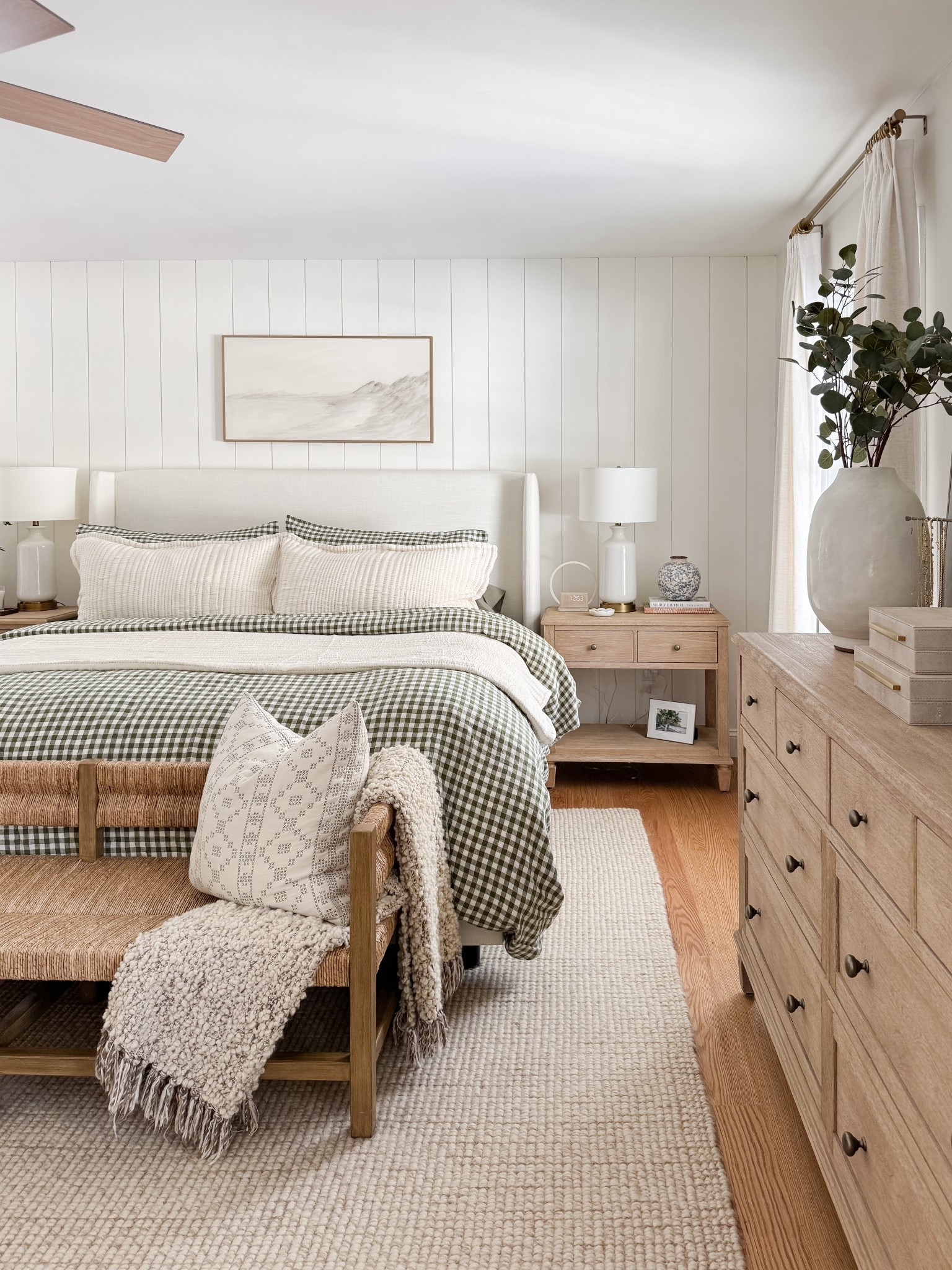 Neutral coastal bedroom with gingham bedding, layered throw blankets, textured knit coverlet, and soft patterned pillows. Light wood nightstands and white table lamps create a calm, layered spring bedroom look. 
gingham bedding, neutral bedroom decor, layered bedding, spring bedding, coastal bedroom, throw blanket, knit coverlet, patterned pillows, light wood nightstands, white table lamps, cozy bedroom, serene bedroom style, sherri calnan home

#LTKHome