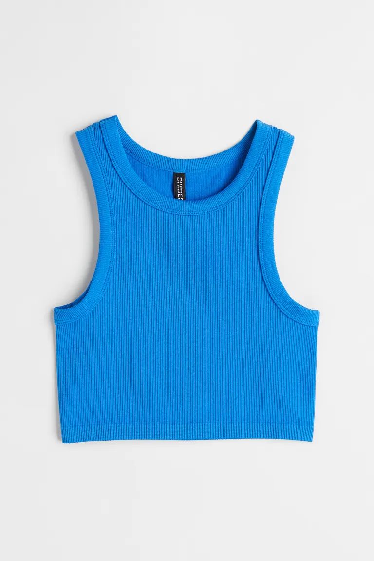 Short, fitted tank top in ribbed jersey. Narrow cut at top with a round neckline.SizeThe model is... | H&M (US + CA)