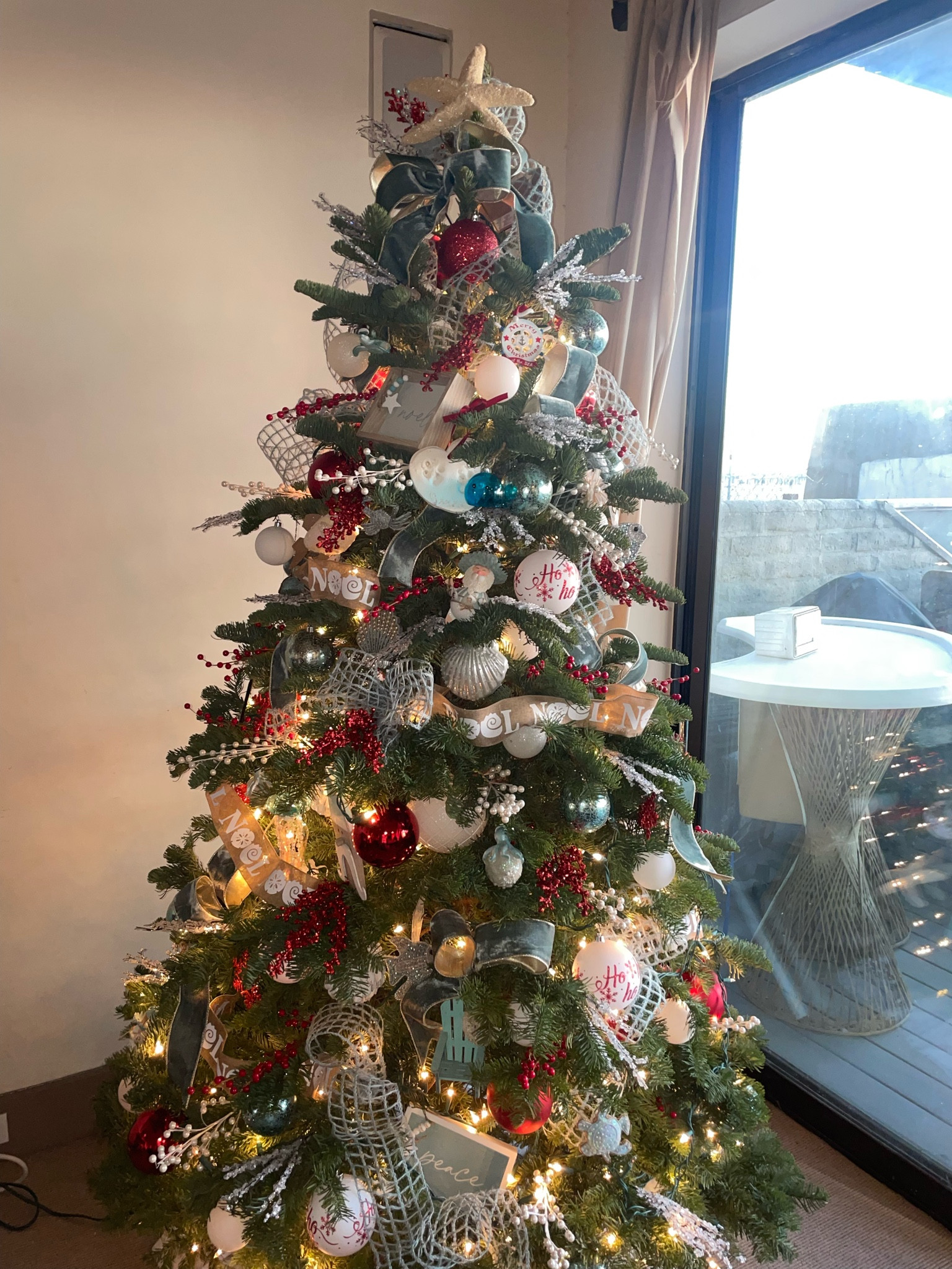 Beach themed Christmas tree. We filled this coastal tree with blue ribbon, lots of ornaments and picks. We used a pop of red and love how festive it feels  

#LTKSeasonal #LTKhome #LTKHoliday