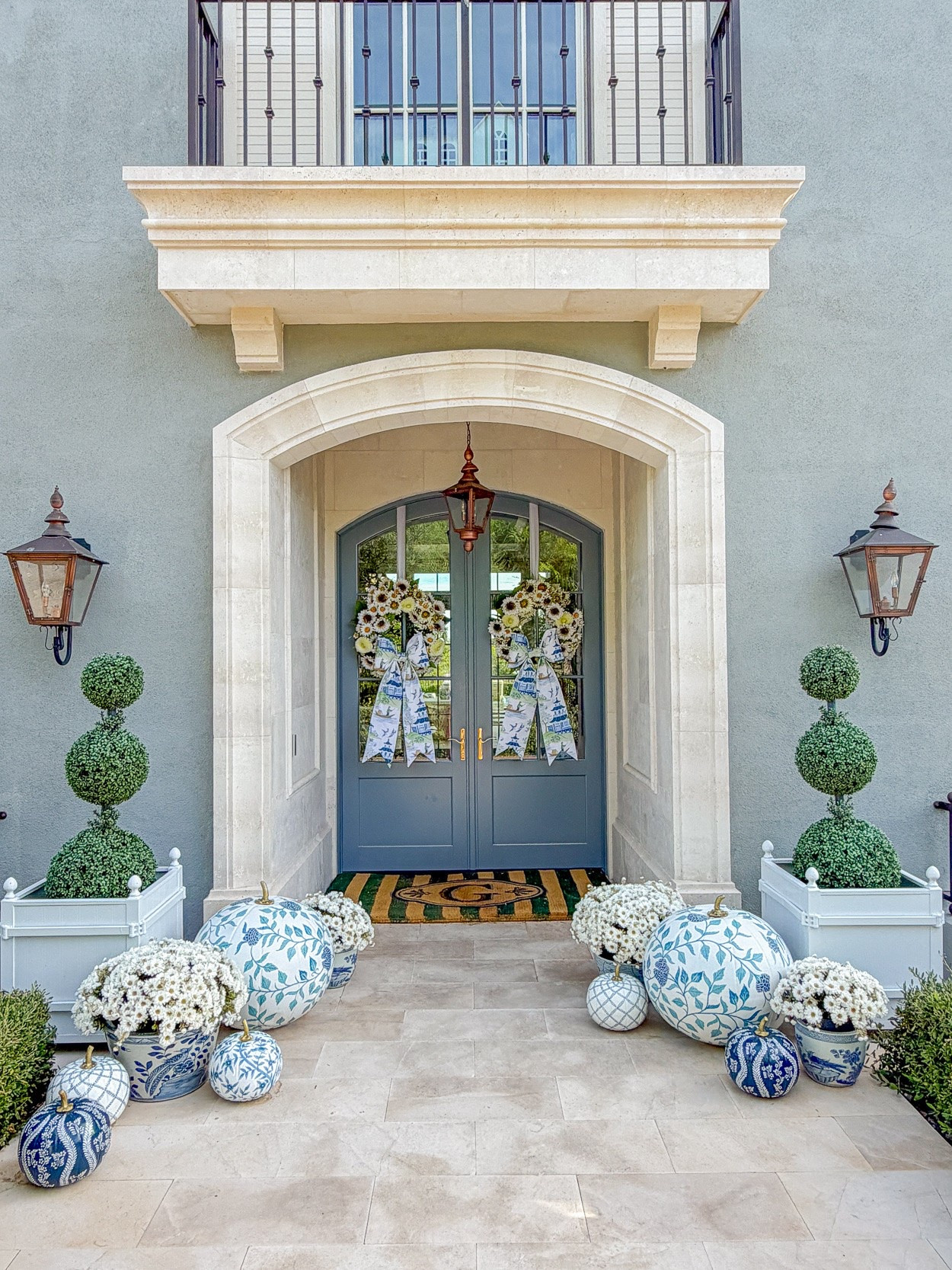 Blue and white fall porch! You’ll love these sunflower wreaths, blue and white pumpkins, faux zinnias and boxwood topiaries. The monogrammed doormat comes in single and double door sizes. The French planters also come in several colors.