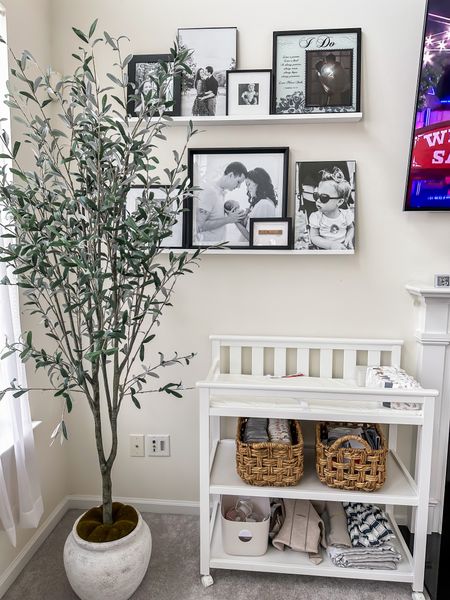 Family room picture frame ledge // black and white picture frames // studio McGee Target faux tree // changing table on wheels // target baskets 

#LTKbaby #LTKhome #LTKfamily