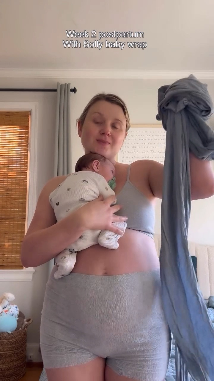Week 2 postpartum, still in pjs, slowly moving again, getting a shower & sleep when I can 😅🩷 when I need both hands, the @sollybaby wrap is saving me yet again. With a toddler, this is a non-negotiable. I remember using it so much with Tatum, now with my little Aria 🦋 linking it and they now have so many fun patterns!! #Postpartum #sollywrap