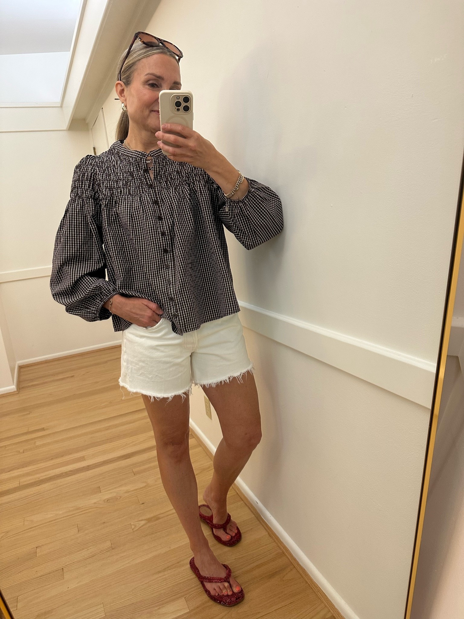 Cutest @Avara gingham long sleeve top with fun smocking detail! Styling for summer with white denim shorts and a pop of red flip flops. Wearing small in top and 26 in Agolde shorts.

#LTKootd #LTKOver40 #LTKTravel