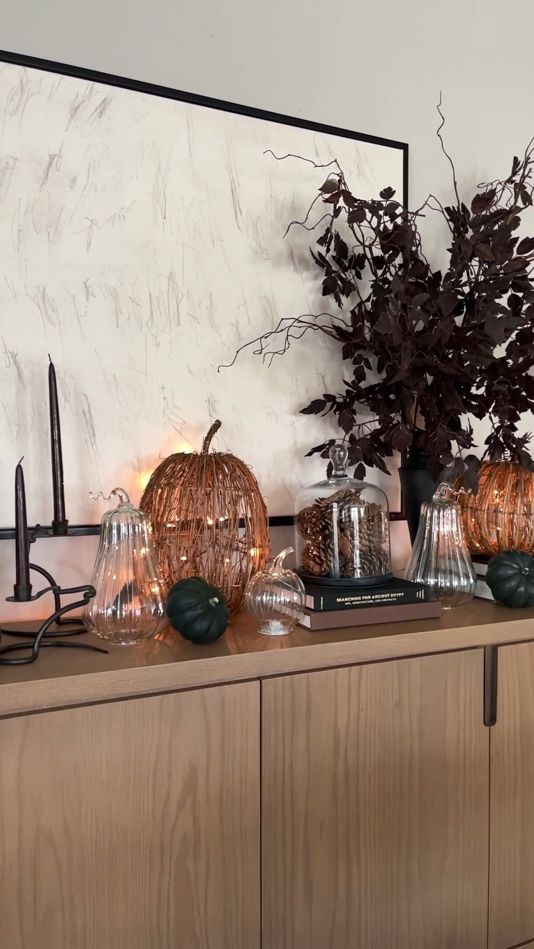 Style my sideboard with me for fall! I bought these glass pumpkins last year, and I can already say they’re going to be a staple in my fall decor for years to come. My candlesticks are vintage, but I will wink some some other ones. And my Phone branches that I used or some of the best sellers on Amazon and they’re the dupe of the high-end version.