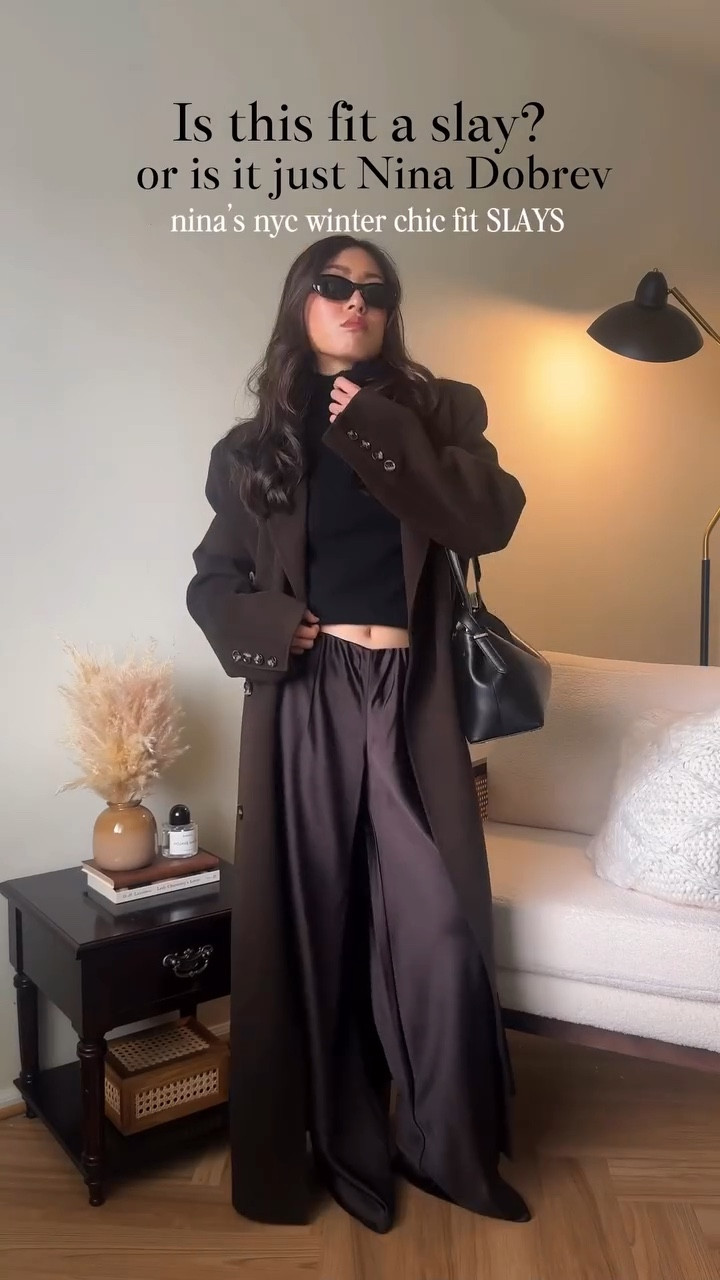 ONE styling tip that makes this outfit go from NAY to SLAY for a short girl 🤎 >>> the peak of skin from the top to the trousers (and I really do mean just a peak! - you don’t need to make this a full crop top!) why? The gap helps give your body some length! We short girls are already at a disadvantage with the long coat, long flowy trousers, and turtleneck! What a knock out combo ❌❌❌ to make us DROWN in our clothes! 🕰️🙉 So doing that littttlleeee tuck of the shirt restores some of that height and adds just a bit of chic flair to this otherwise tall girl outfit! Nina Dobrev, you are an ICON 🤎

Want more Pinterest and celeb recreation outfits? I got you! Follow @amandacapsulewardrobe cause I LOVE making these for my fellow short queens! 

🔗 Outfit specifics always linked in bio → LTK @amandacapsulewardrobe
⸻

#chicoutfit #petiteoutfits #pintereststyle #capsulewardrobechallenge  #ninadobrevstyle recreating Pinterest outfits, recreating influencer outfits, is it the outfit or is she just tall, recreating celebrity outfits, Pinterest outfit inspiration, chic minimalist style, capsule closet inspiration, how to style a long wool coat, how to style satin trousers, minimalist style, effortless looks, Nina Dobrev outfit ideas, Nina Dobrev casual street style, short girl styles, petite styling, 5’2” height