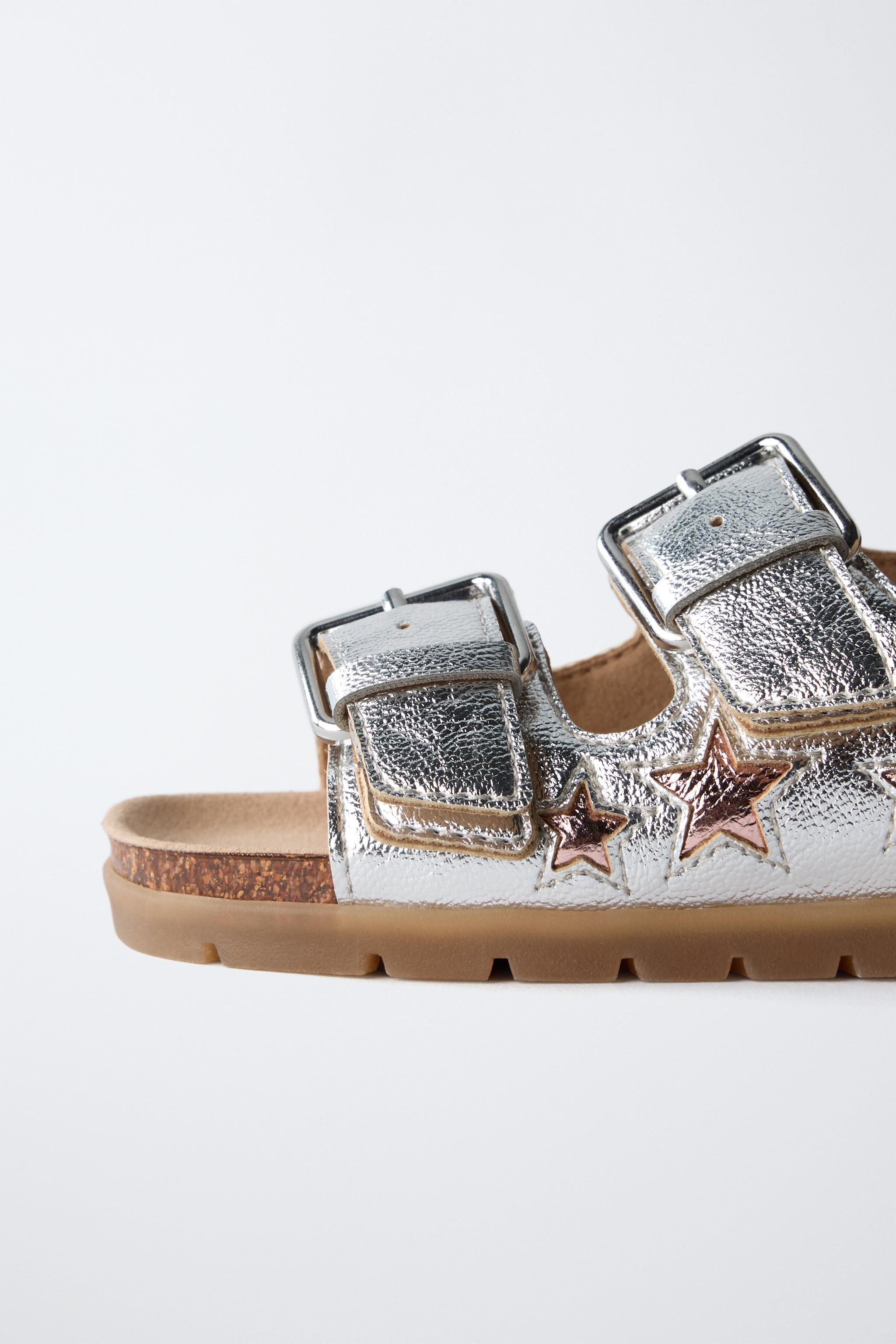 Metallic double strap sandals with star detail. Adhesive back strap closure. Rubber sole. | Zara US