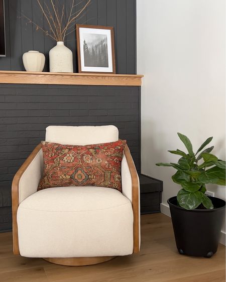 Cozy swivel chair with beautiful throw pillow. White vases. Black planter. Fiddle leaf fig. Living room furniture. Fireplace decor. Arhaus chair. Hewn Elite Mendocino Stoneform flooring.

#LTKhome