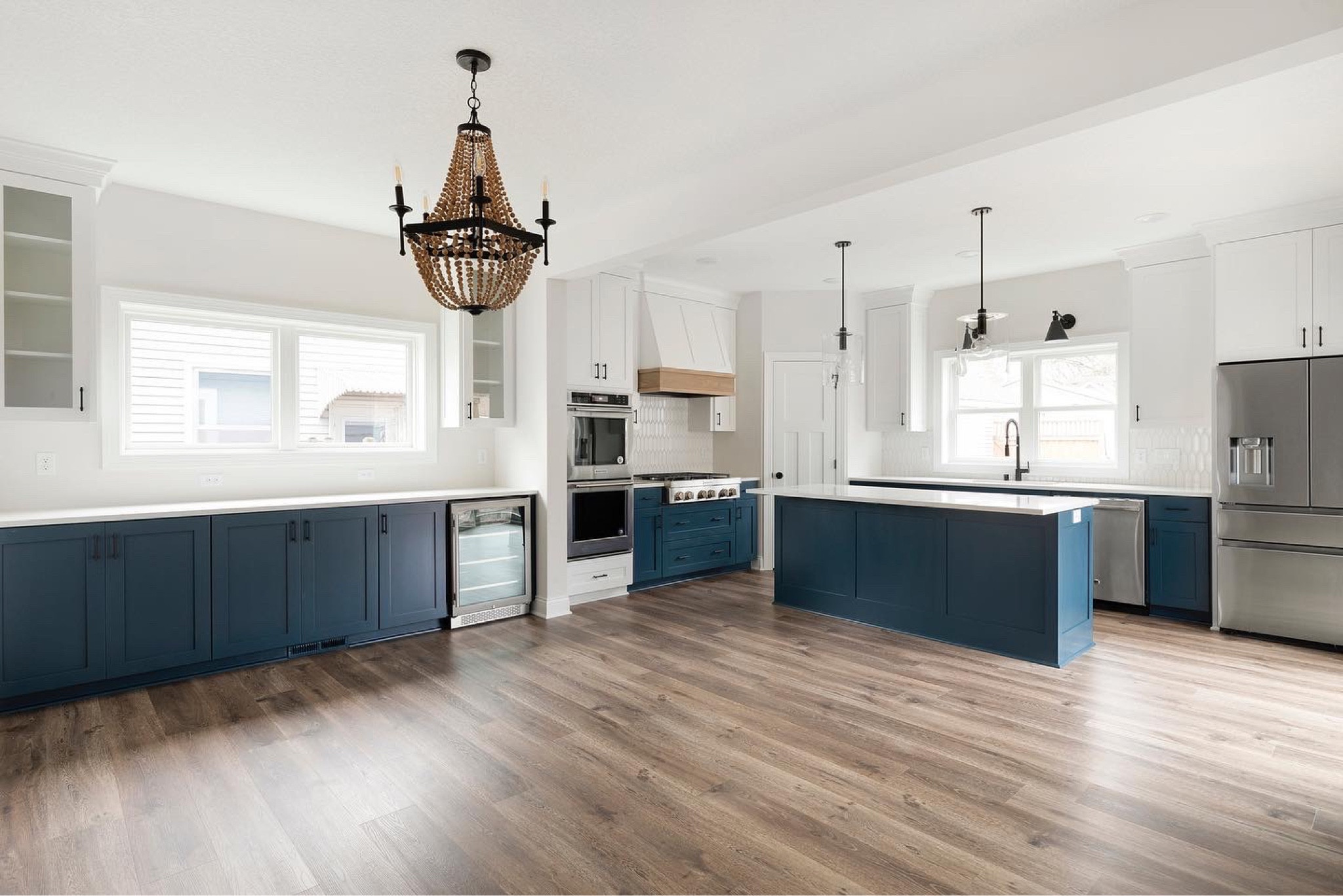 Are you team neutral or colored kitchen cabinets? 👇 Our clients at the #uptonupdate love to entertain, so creating a warm and inviting kitchen and bar space for them to enjoy was a must. Can we talk about that counter space? The gorgeous navy paint color added a much-needed pop of color! 💙 #almahomes 