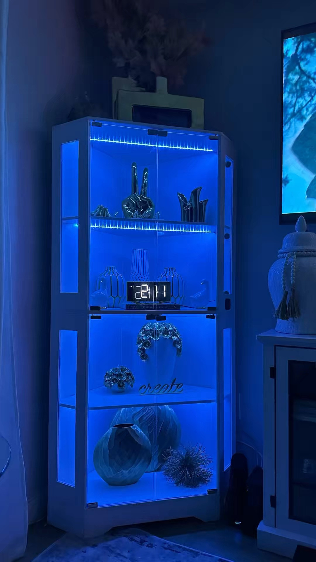 Unboxed luxury ✨ When @garvee_official said corner cabinet, I didn’t expect THIS. 67” tall, glass doors, built-in LED that literally transforms my whole living room corner.

I styled it with my gold accents, vases & a little “create” magic and I’m obsessed. The blue glow at night? Chef’s kiss.

Corner glow-up: unlocked 🔓💙
From flat box to full glam. This GARVEE Corner Display Cabinet with LED lights was so easy to assemble and instantly elevated this empty dark corner.  I may get a second one to complete the other corner!

#LTKvlog #LTKHome #LTKSaleAlert